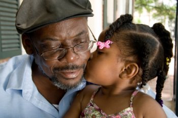 Little girl kissing grandfather.