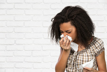 Woman sneezing.