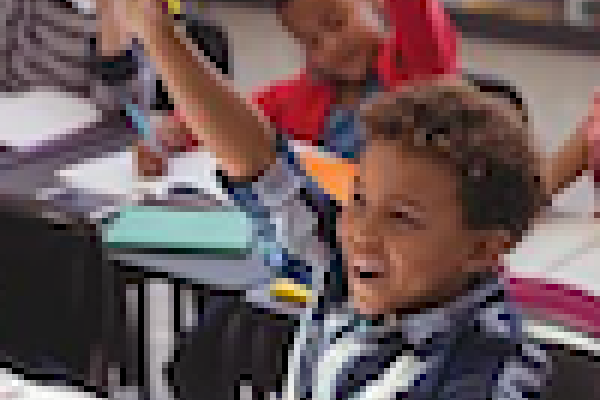 classroom with children raising hands