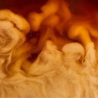 Close up of milk mixing into coffee (Image: Adobe Stock)
