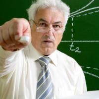 Maths Teacher pointing with chalk at camera